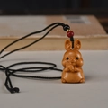 Handgeschnitzter hölzerner Hasen-Anhänger mit Kordel und Glücksperlen-Detail - Hase Halskette