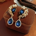 Gros plan de boucles d'oreilles vintage dorées avec pendentif saphir bleu goutte - Or-Bleu