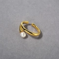 Detalle de un elegante anillo de latón dorado con perla blanca sobre fondo oscuro - 1 Pieza Clip de Oreja / Dorado