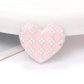 Detalle macro de dije de corazón en aleación de zinc con esmalte rosa damero y perlas - Rosa