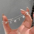 Silver heart and star charm bracelet with delicate bead chain shown held by hand - Silver Heart Bracelet (Adjustable)
