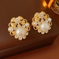 Dettaglio di orecchini vintage a fiore con perle e cristalli su scatola in pelle - Stile Orecchino a Bottone Fiore Oro