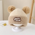 Dettaglio del berretto in maglia beige con due pompon e una toppa con lettere Sweet Time - 2-5 Anni / Lettere Sweet Time / Bianco Sporco