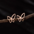 Pendientes de mariposa huecos minimalistas en oro rosa sobre rama natural - Oro rosa