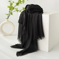 Elegant black cotton linen scarf with fringe edges draped over a white minimalist display - Black