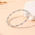 Detailed close-up of a silver stainless steel bamboo style bangle on a white stone base - Steel Bamboo Style (S102)