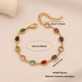 Macro shot of colorful teardrop gemstone charms on a polished gold stainless steel bracelet - Waterdrop Style