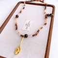Dettaglio di collana vintage con perline in legno e ciondolo a cucchiaio dorato unico - Ciondolo a Cucchiaio Oro (WN2110) / Oro