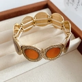 Dettaglio del bracciale dorato vintage maculato con intarsio in resina arancione e bordi lavorati - Intarsio in Resina Arancione / Oro-Arancione-Caffè