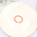 Pastel pink high-elasticity hair tie with matching cylindrical connector on ceramic plate - Orange