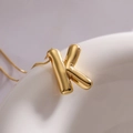 Minimalist golden balloon letter K pendant necklace with polished finish on a slim chain - Letter K