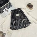Detailed flat lay of plaid patchwork drawstring backpack with cotton woven ropes - Black