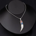 Close-up of vintage faux wolf tooth necklace with red and blue accents on a black bust - Drip Oil Wolf Tooth