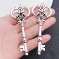 Detail view of two antique silver heart crown key pendants held in hand for scale - Large Crown Key (4175)