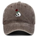 Close-up of vintage skull and red rose embroidery on a washed cotton baseball cap - Coffee