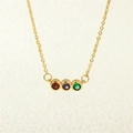 Close-up of gold 18K necklace featuring three round red, purple and green gemstones - 3 Zirconias Style (NE1616)