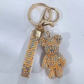 Macro detail of orange rhinestones and gold clasp on the violent bear keychain charm - Peach Mix