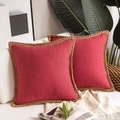 Detail of red linen cushion covers with decorative rope piping on a soft sofa - Red