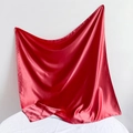 Detailed view of red satin fabric corner showcasing glossy silk texture and soft drape - Satin Finish / Watermelon red