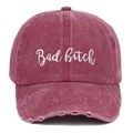 Macro detail of wine red distressed cotton cap with white Bad Bitch embroidery - Distressed Wine Red