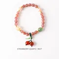 Detalle de pulsera de cuarzo fresa con un dije de cereza y detalles en color dorado - Estilo Cuarzo Fresa Cereza Perla (WB335)