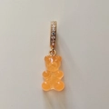Macro detail of an orange gummy bear resin pendant with gold zircon-studded clasp - Transparent Orange