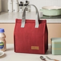 Red insulated lunch bag with grey handle and Tasty Food leather patch in kitchen setting - Burgundy