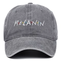 Dettaglio del ricamo bianco Melanin su un berretto da baseball grigio antracite lavato - Grigio