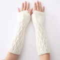 Macro view of cream knit arm warmers showing detailed cable stitch texture and thumb hole - White