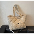 Detail of beige quilted tote bag featuring diamond pattern stitching and front snap pocket - Off White