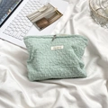 Detail of mint green textured makeup bag with soft pleated fabric and silver zipper - Light Green