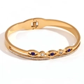 Gold plated beaded evil eye bracelet with blue and white zircons on white background - Blue Evil Eye Pave Zirconia Spring Bangle