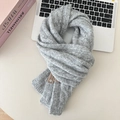 Close-up of soft grey knit wool scarf with a high-quality cable-knit texture and pinda label - Light Gray