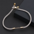 Détail du bracelet en cordon tressé gris ajustable avec accents métalliques dorés - Gris