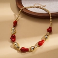 Dettaglio della collana con perle di acrilico, sfere dorate e pietre rosse irregolari - Rosso