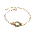 Macro shot of gold hip hop bracelet with green zircon center and adjustable chain link - Green