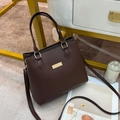 Close-up of deep brown leather handbag with gold metal hardware and textured PU finish - Coffee
