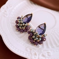 Macro view of vintage teardrop purple crystal earrings with beaded accents on ceramic - Purple (Silver Earring Post)