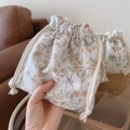 Detailed view of cream velvet drawstring pouch showing delicate floral and bunny print - Rabbit with Yellow Flowers