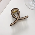 Detail of a brown textured claw clip with visible golden metal spring and inner lining - E-Brown Textured