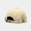 Detalle de hebilla metálica y logo S en el gorro docker beige sin ala - Beige
