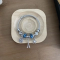 Silver beaded bracelet with blue glass charms and Eiffel Tower pendant on wood tray - Tower Bracelet