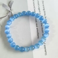 Elegant 8mm blue cat eye stone beaded bracelet displayed on a white gift box - Light Blue Cat's Eye