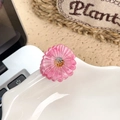 Rosa Gänseblümchen Haarklammer mit braunem Staubblatt auf einer weißen Platte - Gänseblümchen / Rosa