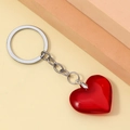 Close-up of translucent red 3D resin heart keychain with silver metal ring and chain - Red