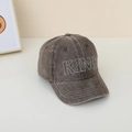 Dettaglio del ricamo KING sul cappellino da baseball per bambini in denim lavato - caffè
