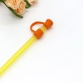 Reusable orange silicone straw cap with sealing plug on yellow straw - Orange