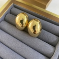 Makroaufnahme polierter goldener ovaler Ohrstecker auf einer grauen Schmuckschatulle - Gold Mittel