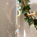 Golden moon and star suncatcher with crystal prisms hanging on a green branch - B8 Style