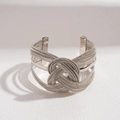 Detailed macro view of the intricate silver woven metal chain and central knot design - Silver